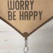 Don't Worry Be Happy piano roll.  Our vintage piano roll sign adds unique charm and one-of-a-kind gift giving for the music lover in your life!  D E T A I L S • Each piano roll is vintage and has flaws and character from use and age. • Twine included for hanging. • Black ink printed on piano roll. • Glass crystal included as adornment. • 12" wide x 29" long.